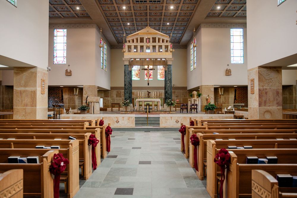 Interior view of a traditional church sanctuary with wooden pews and vaulted ceiling illuminated by natural light.
