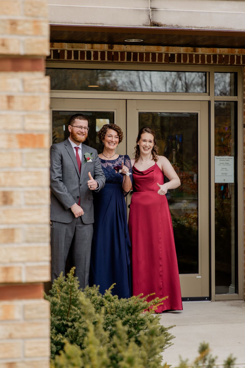 Wedding party members pose together outside the Monsignor Sorohan Center entrance wearing formal attire.
