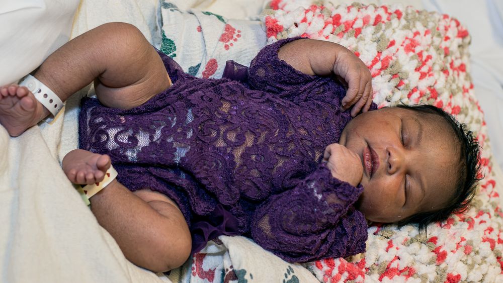 Close-up shots of a newborn baby in purple lace outfit on floral print bedding.
