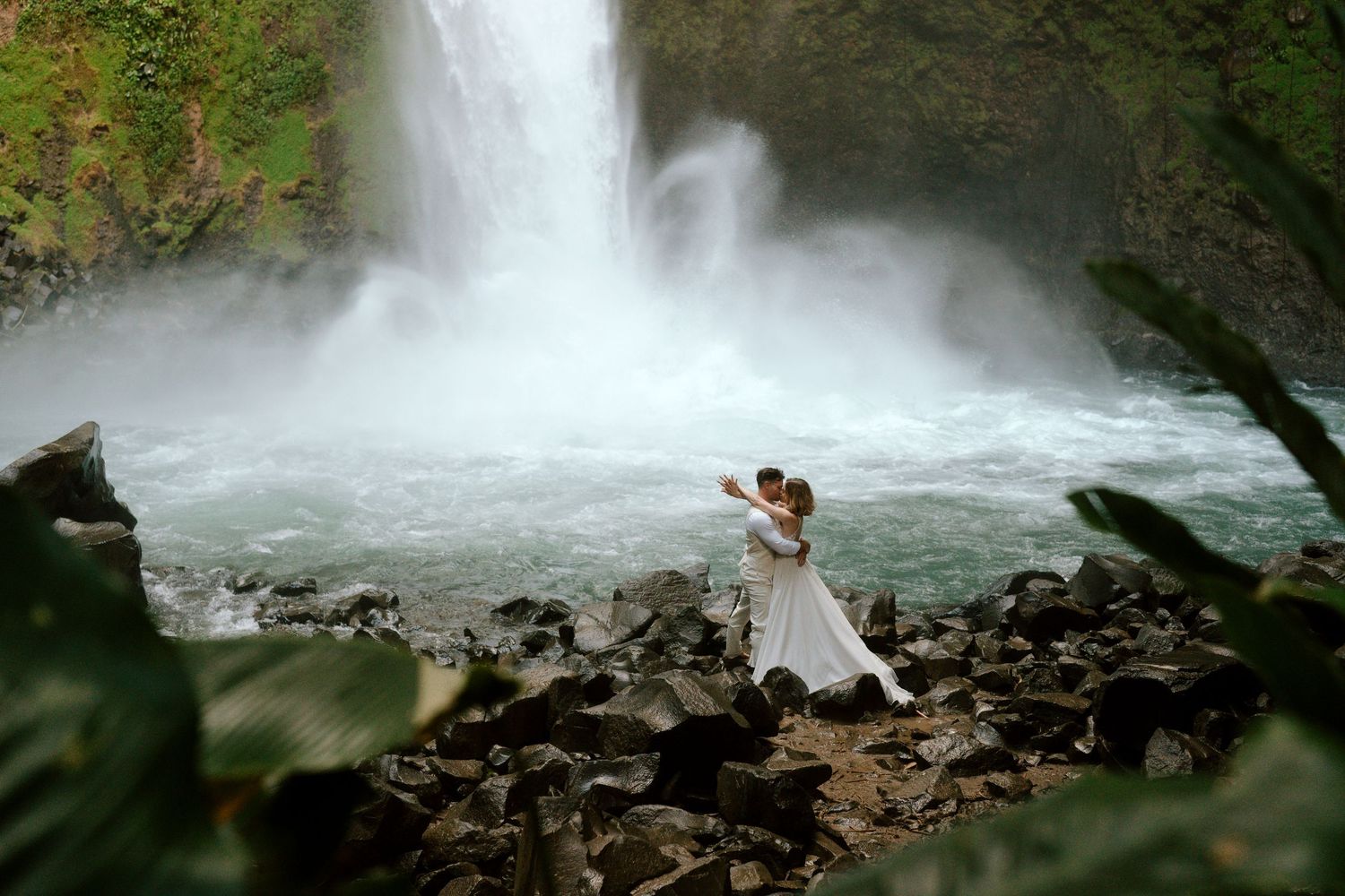 eloped couple hugging in front of La Fortuna Waterfall