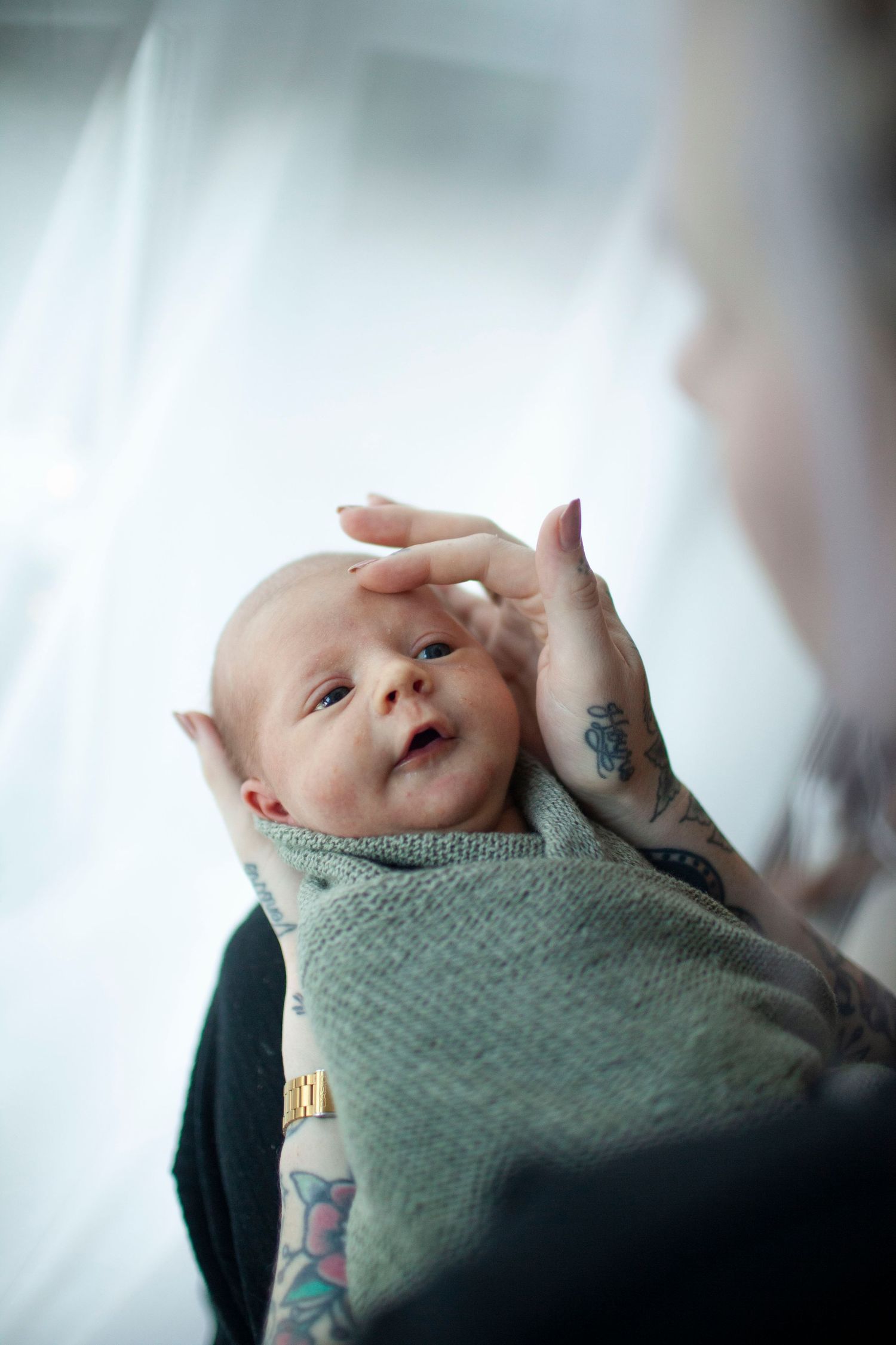 Nyfødtfotograf Stavanger:  Intim lifestyle nyfødtfoto, baby i foreldrenes armer.