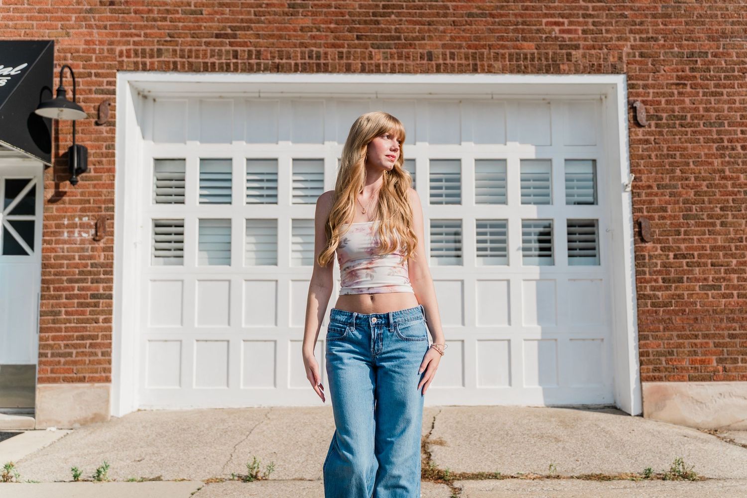 Perrysburg High School senior wearing monochromatic high-fashion outfit poses against white garage door background in Downtown Perrysburg.