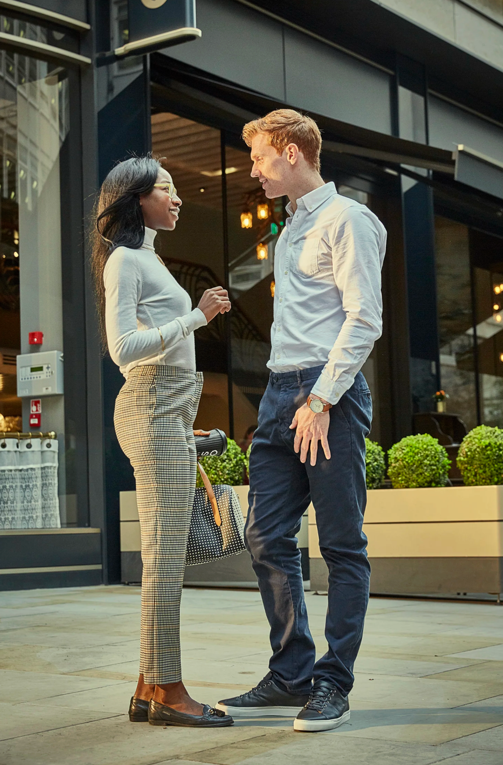 Business professionals having a conversation outside an office building entrance.