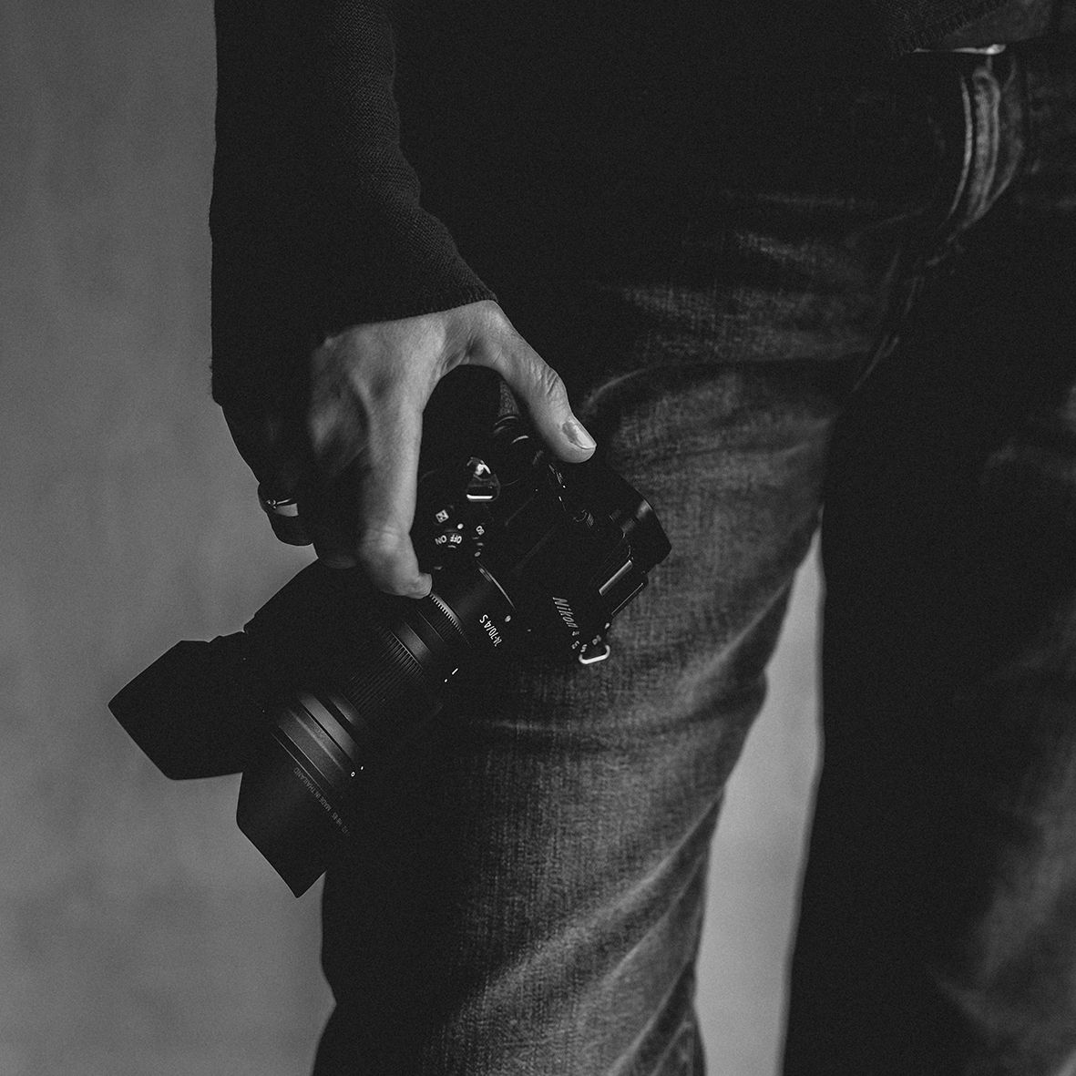 Ein schwarz-weiß Foto. Eine Fotoapparat wird in einer Hand  gehalten. Ein schwarz -Weiß Foto fotografiert im Fotostudio in Gelsenkirchen