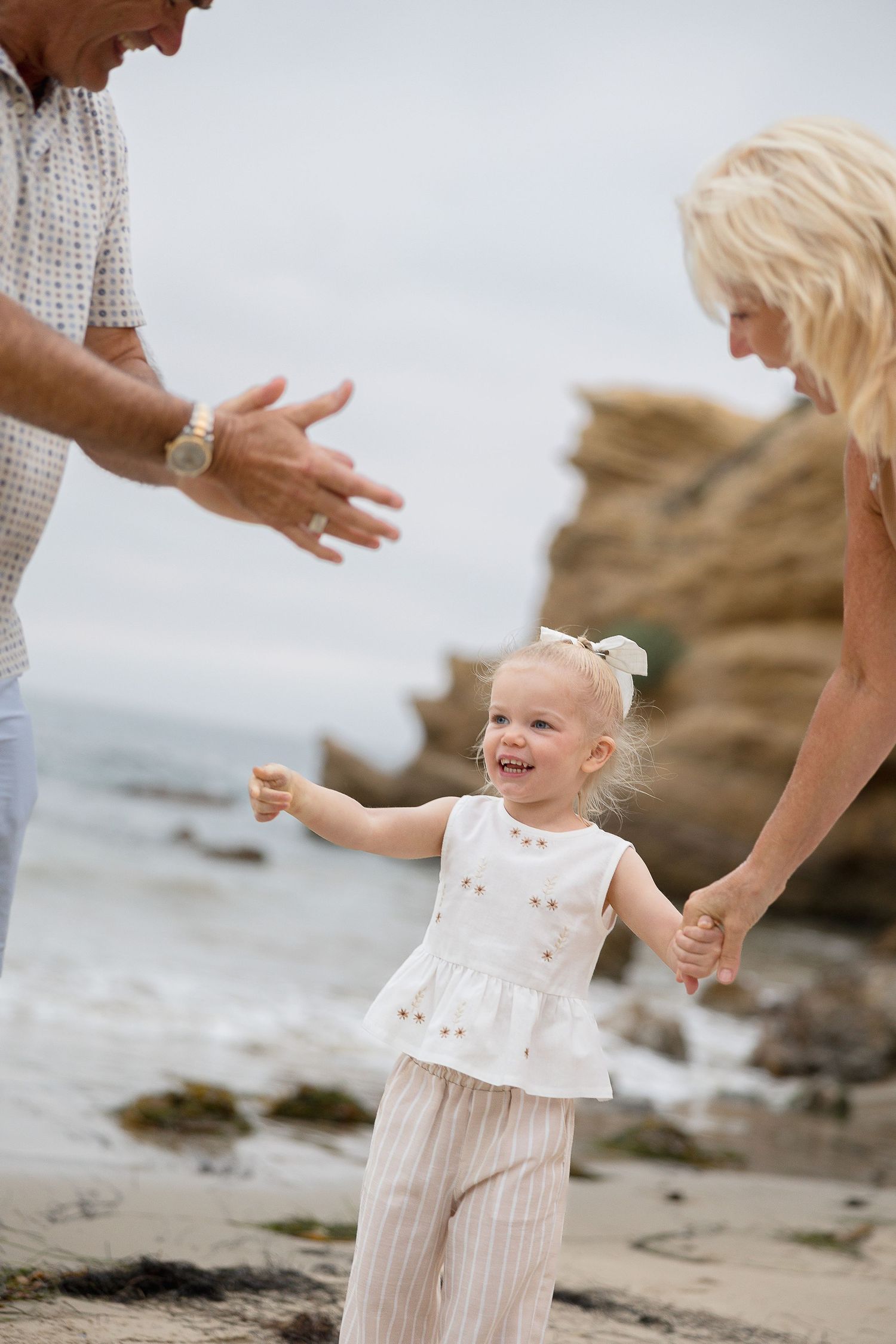Crystal Cove beach family photography with playful candid smiles with grandparents