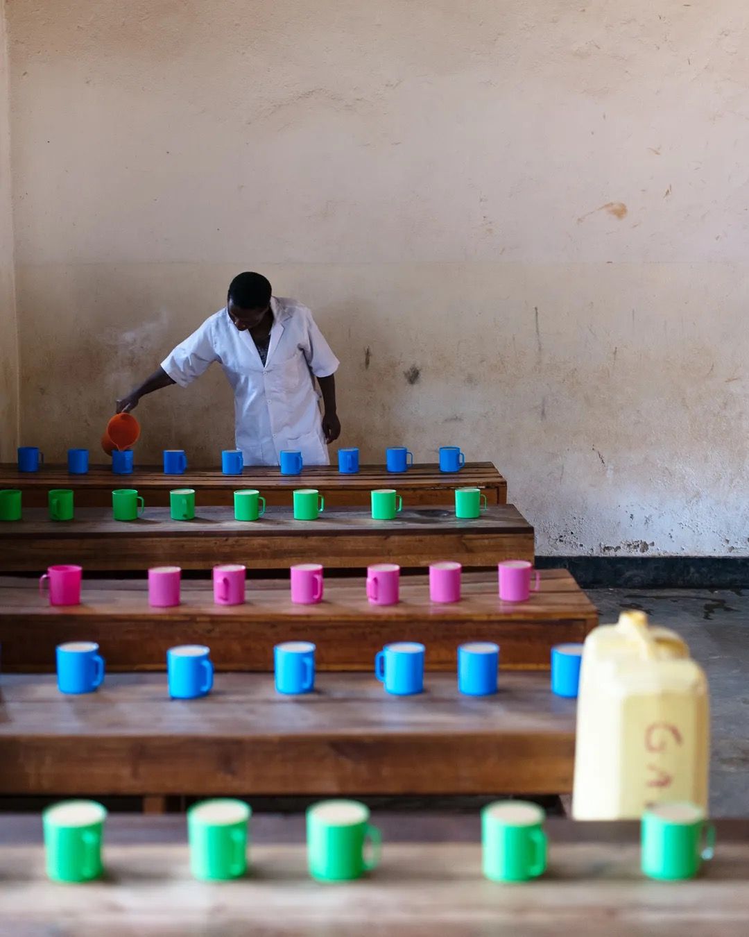 Staff prepare colourful cups for a school meal programme helping improve child nutrition and classroom support.