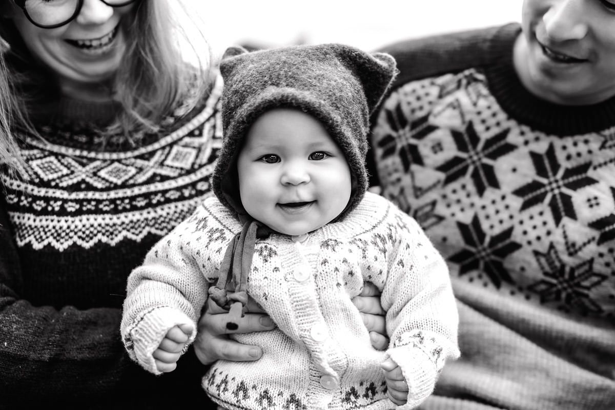 Baby på 7 måneder på julekortfotografering. Svart-hvitt bilde av babyen som smiler.