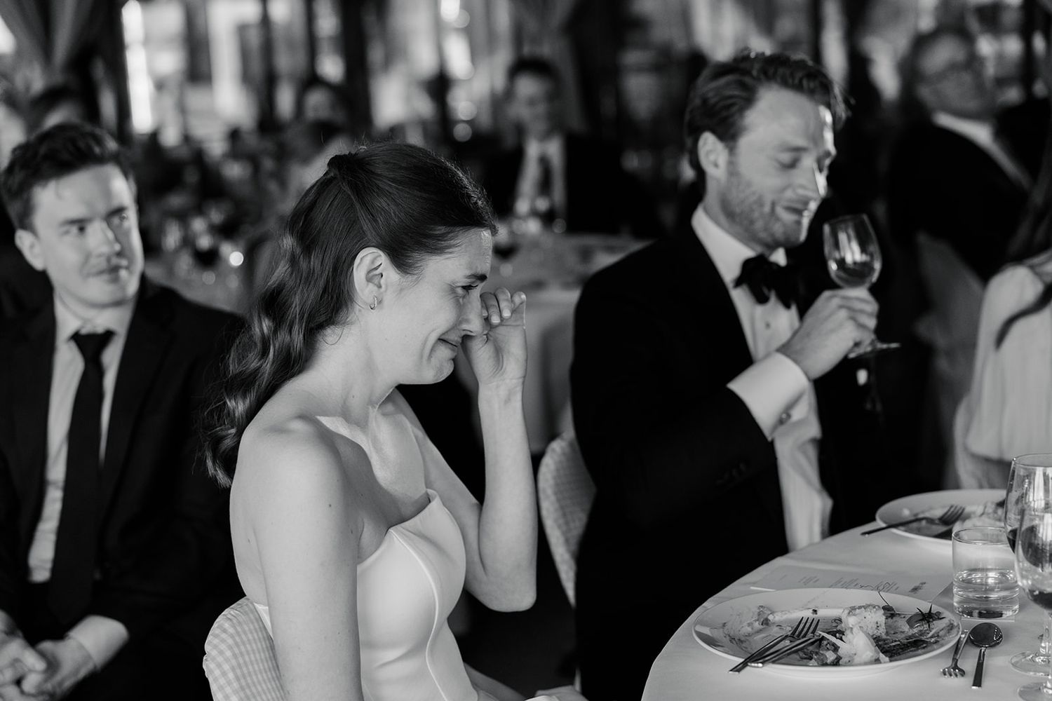 Black and white candid photos showing people laughing and enjoying a social gathering in a casual setting.