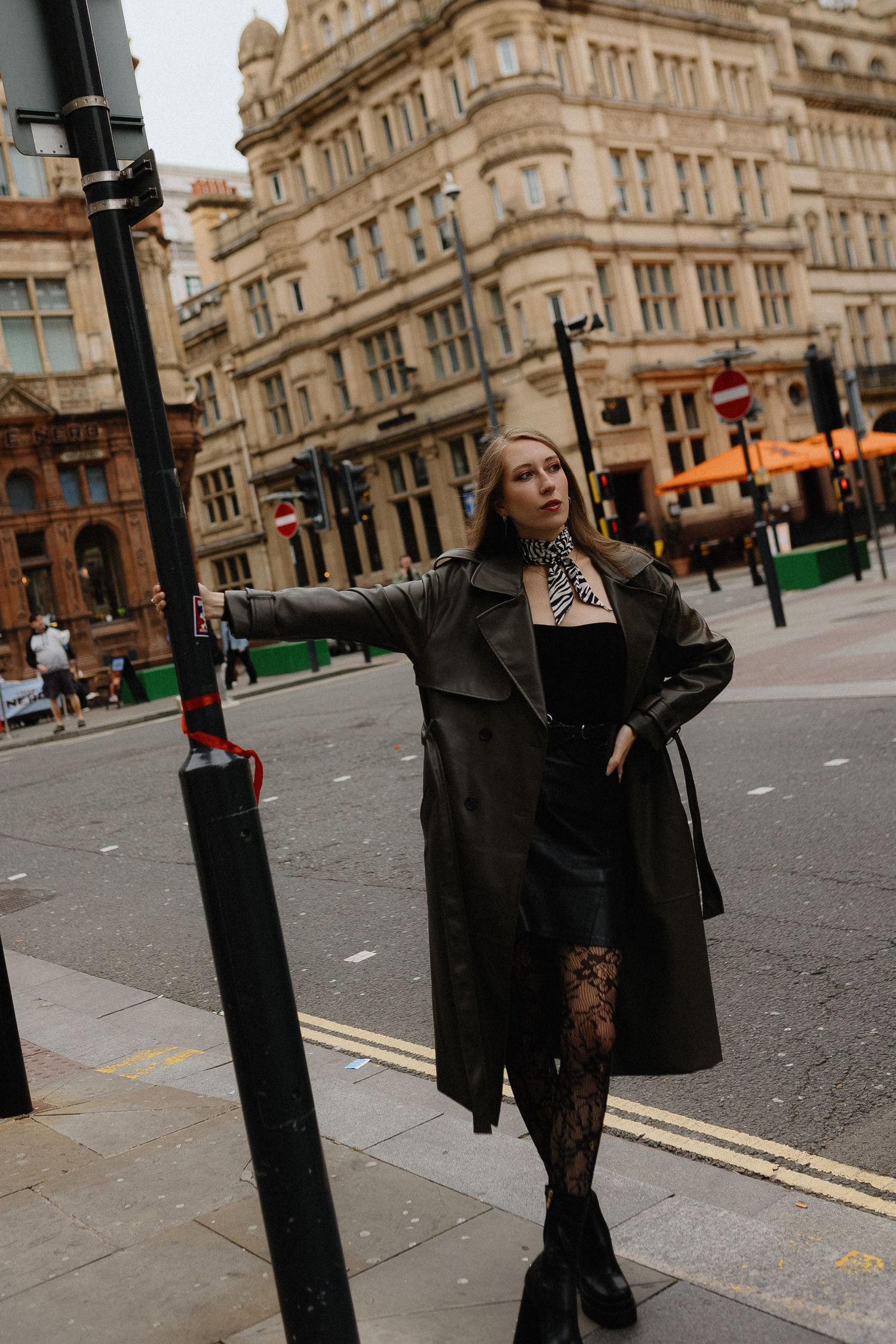 A dramatic fashion portrait series showing a model in black attire posing against a classical stone building facade.