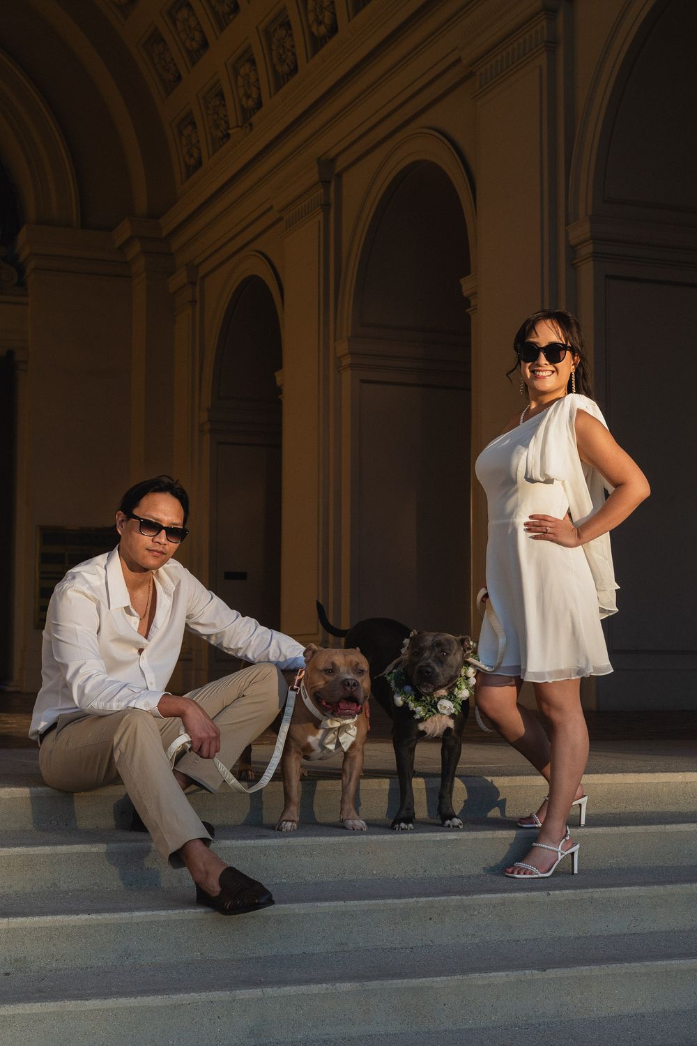 Sweet moment of couple kneeling to pet their dogs at Pasadena City Hall.