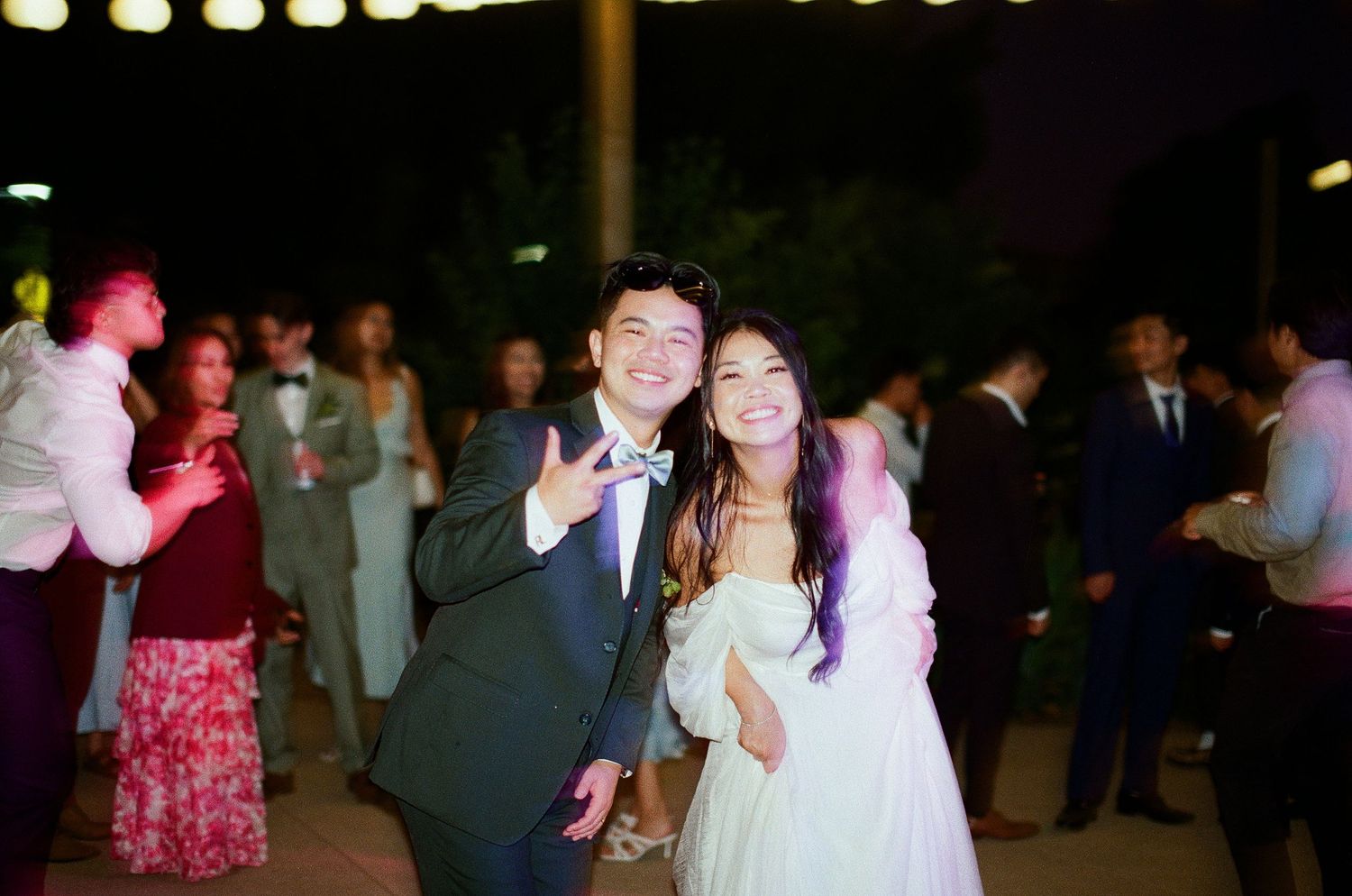 High-energy Orange County film photography capturing the motion and light of a nighttime wedding dance party.