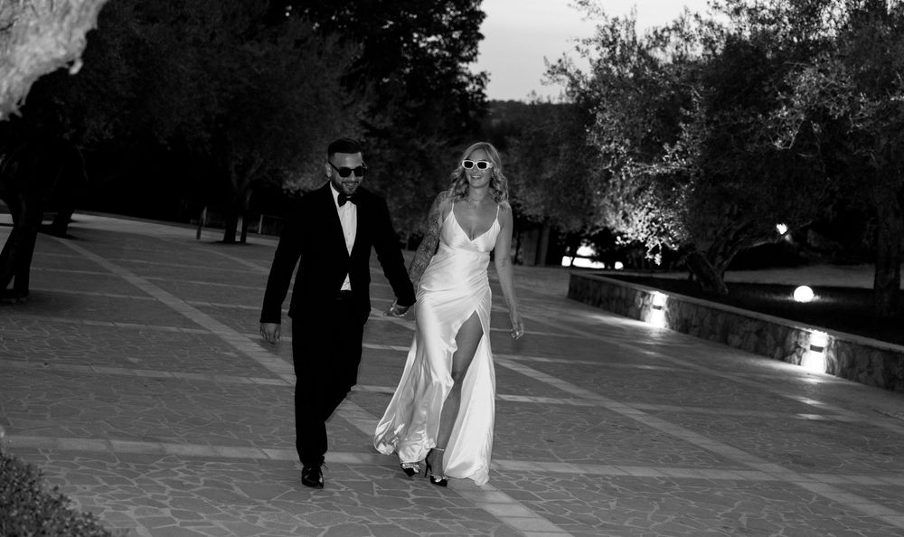 Black and white photo of wedding couple walking together at night.