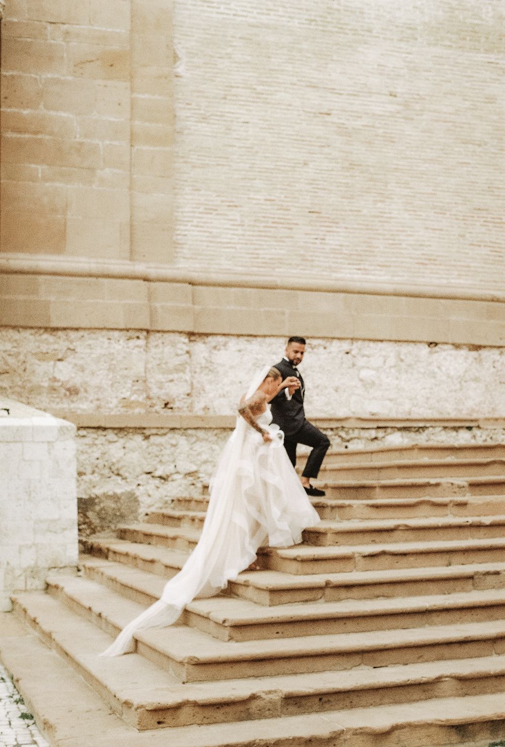A romantic wedding photo sequence showing a couple lounging on stone steps in formal attire.
