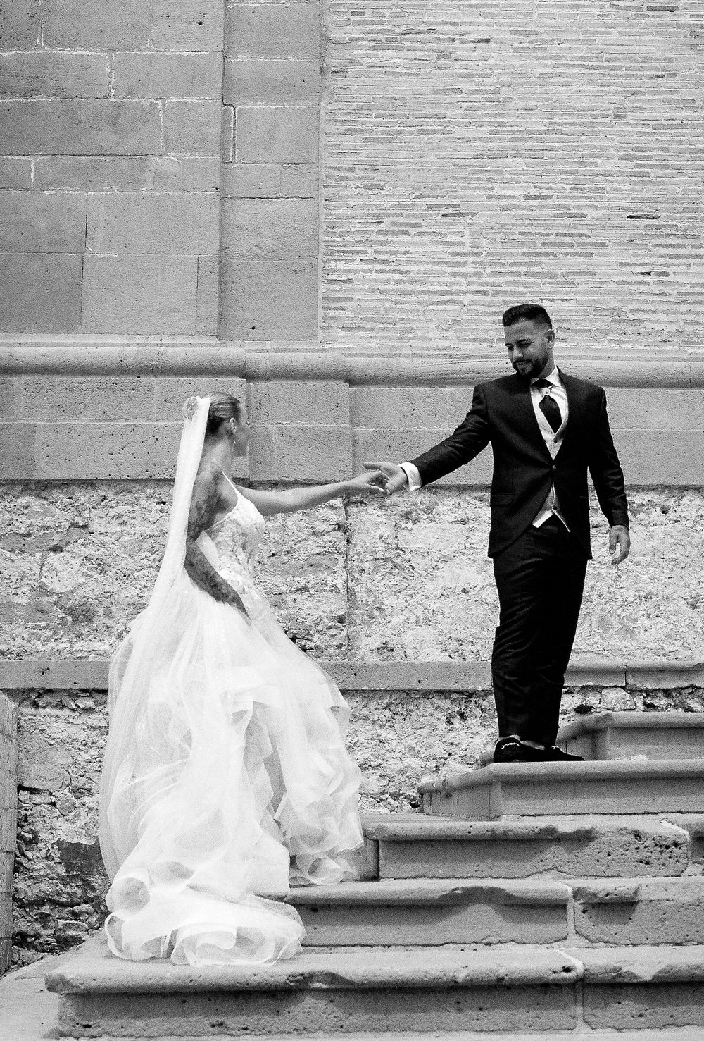 Black and white sequence of a couple posing artistically on stone steps.
