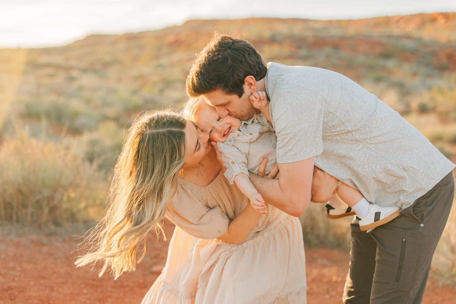 Playful photo session among orange sandstone rock formations in desert setting.