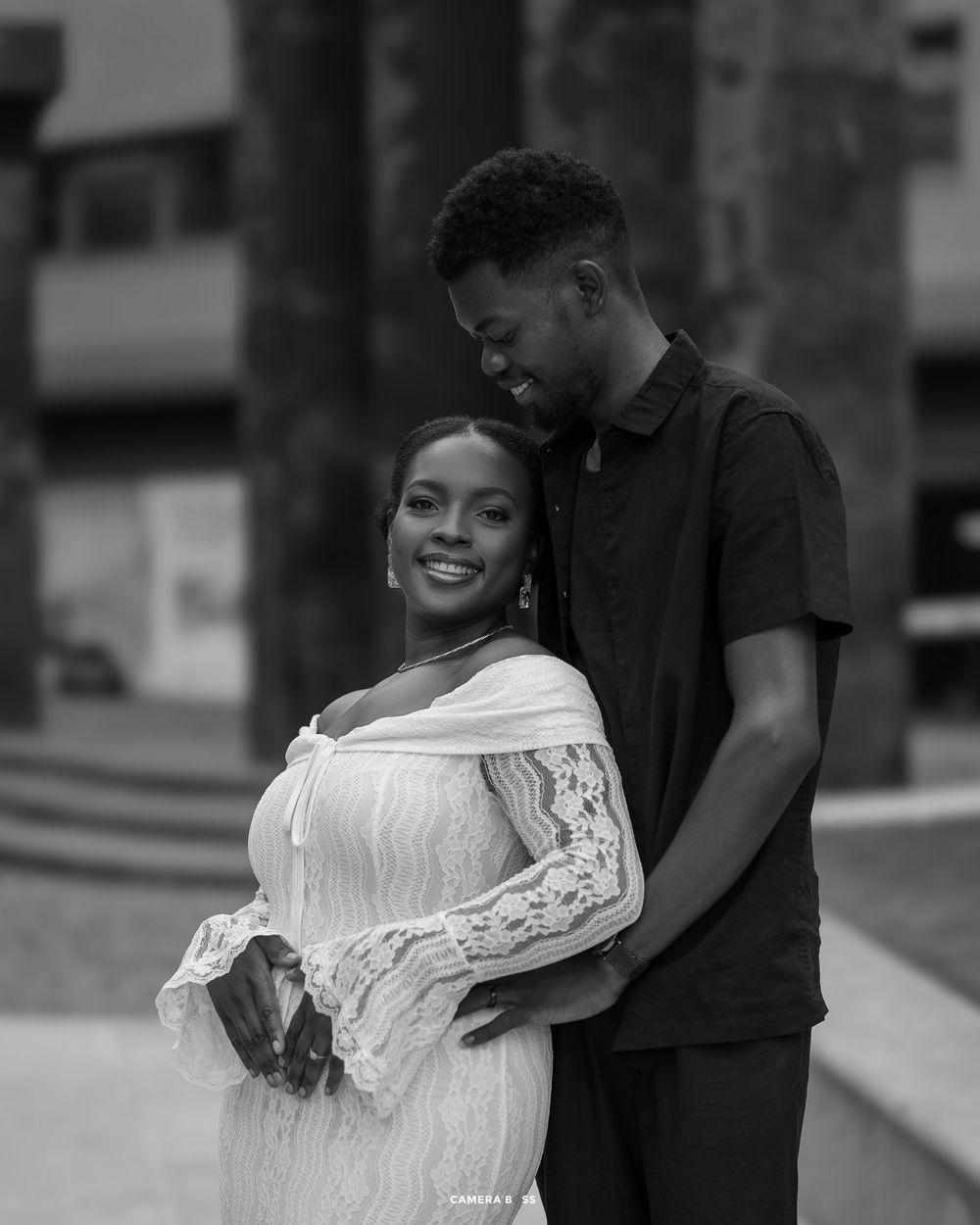 A romantic black and white engagement photo series showing a couple embracing and laughing together outdoors.