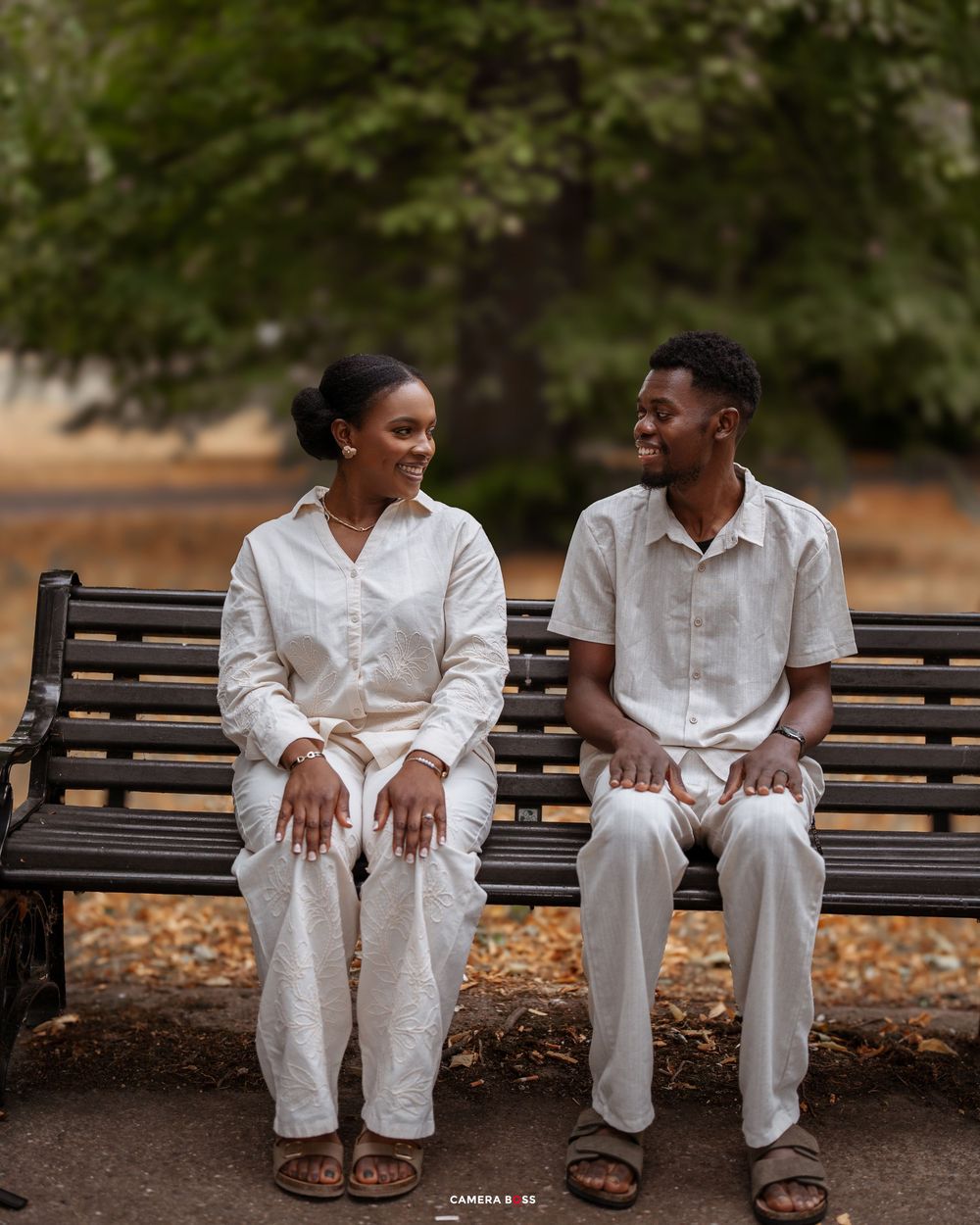 A series of intimate engagement photos showing a couple in matching white outfits sitting on park benches.