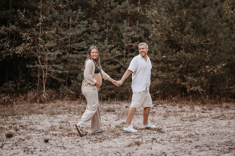 Expecting couple sharing intimate moments in a natural outdoor setting.