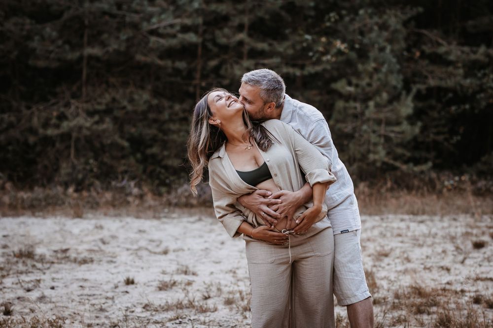 Maternity photoshoot in a rustic outdoor setting with warm earth tones.