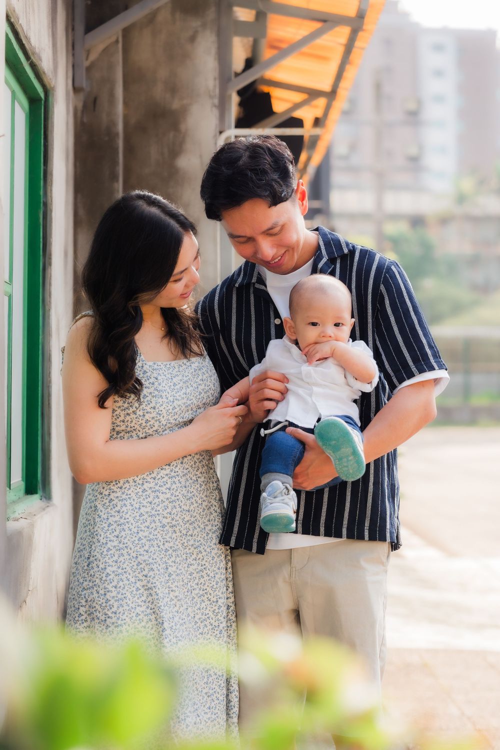 Family shares tender moments with their baby outdoors in a series of connected photos.