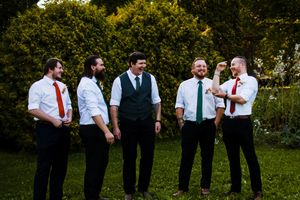 Wedding party stands in line on green lawn during outdoor celebration.