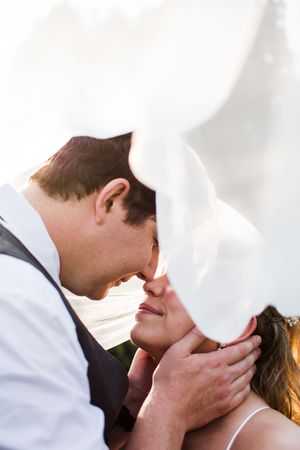 An intimate wedding portrait showing a tender moment between newlyweds.