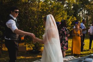 Outdoor wedding ceremony space with natural greenery and golden sunlight filtering through trees.