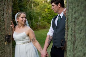 Newlyweds share a candid moment while walking through a garden setting.