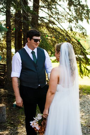 A couple shares an intimate moment in a wooded setting during their wedding photoshoot.