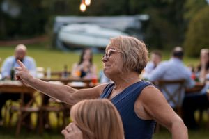Wedding guests raise their glasses in celebration during outdoor reception.