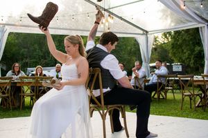 Newlyweds dance under string lights at their tented outdoor reception.