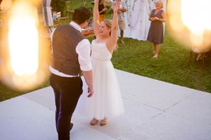 A couple dances during their wedding reception as warm lighting creates a romantic atmosphere.