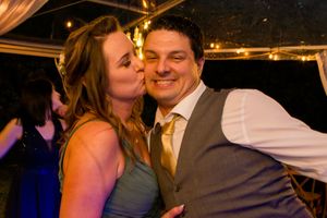 A romantic moment captured during a wedding reception with warm lighting and festive atmosphere.