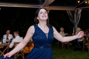 Wedding guests in navy dresses celebrate during an evening reception.