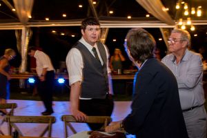 Wedding reception dance floor with hanging lights and white fabric draping creating a romantic atmosphere.