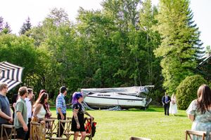 Panoramic view of wedding guests gathered on a grassy lawn for an outdoor celebration.