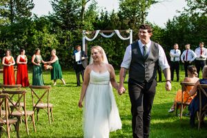 Wedding ceremony in progress on a beautiful summer day with guests watching.