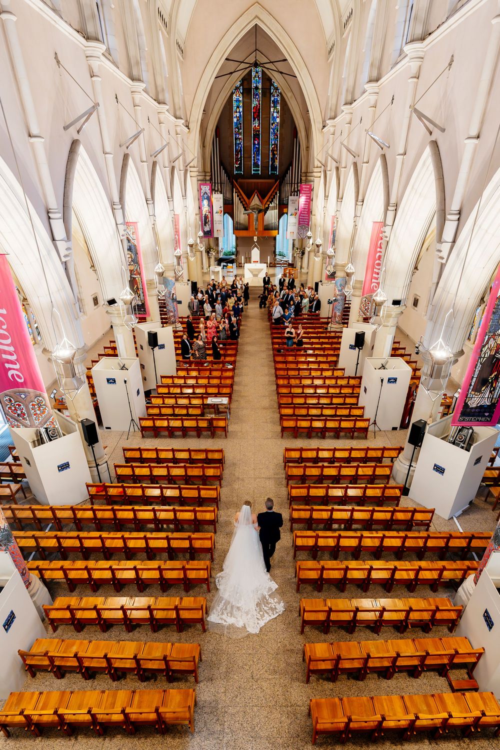 Interior view of a church sanctuary with wooden pews and Gothic arches decorated with banners for a special event.
