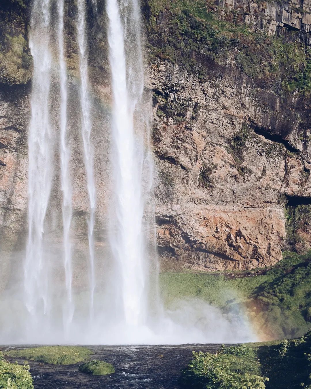 Powerful waterfall cascading over mossy cliffs in Iceland.