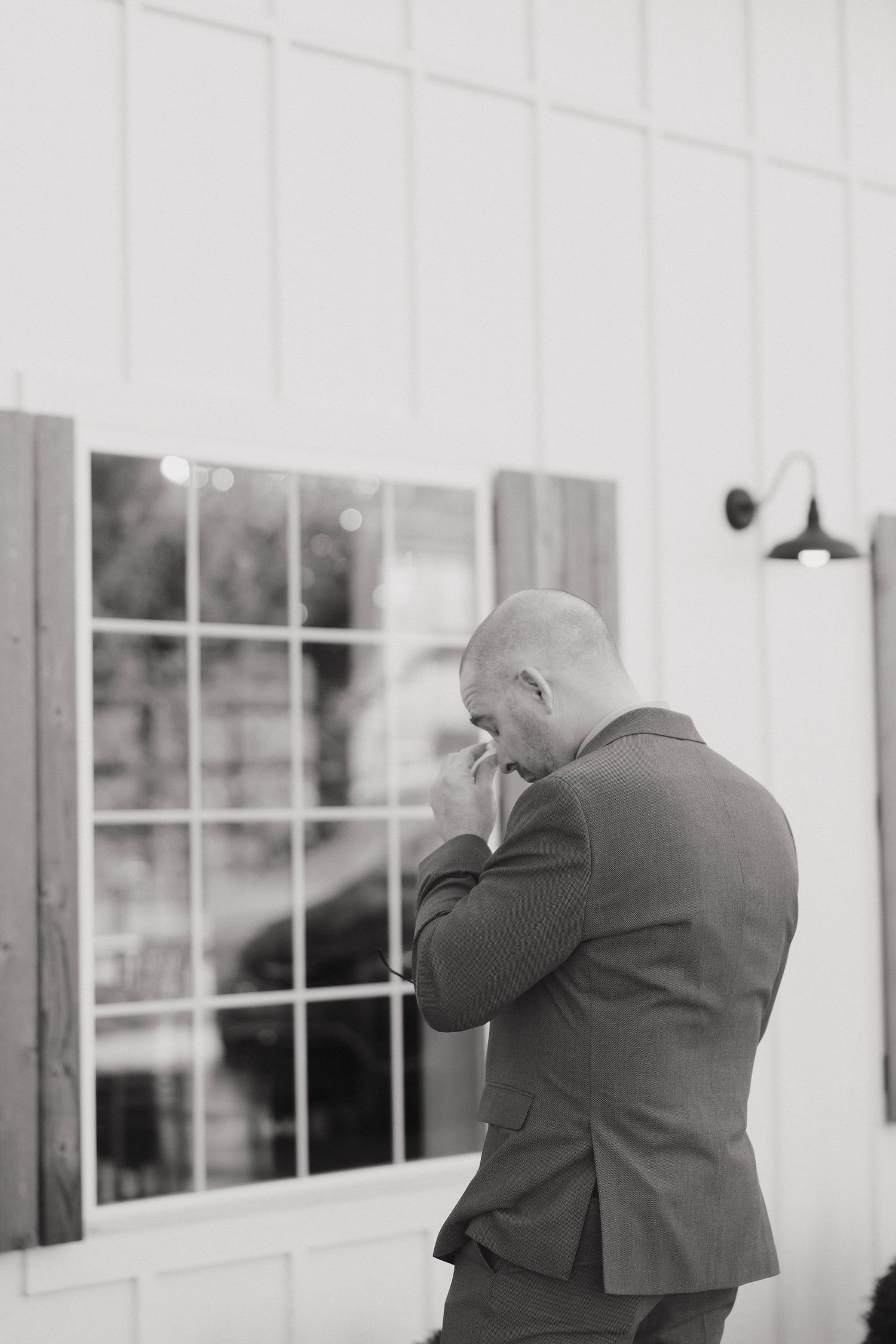 Three photographers in suits take pictures through windows at an elegant venue.