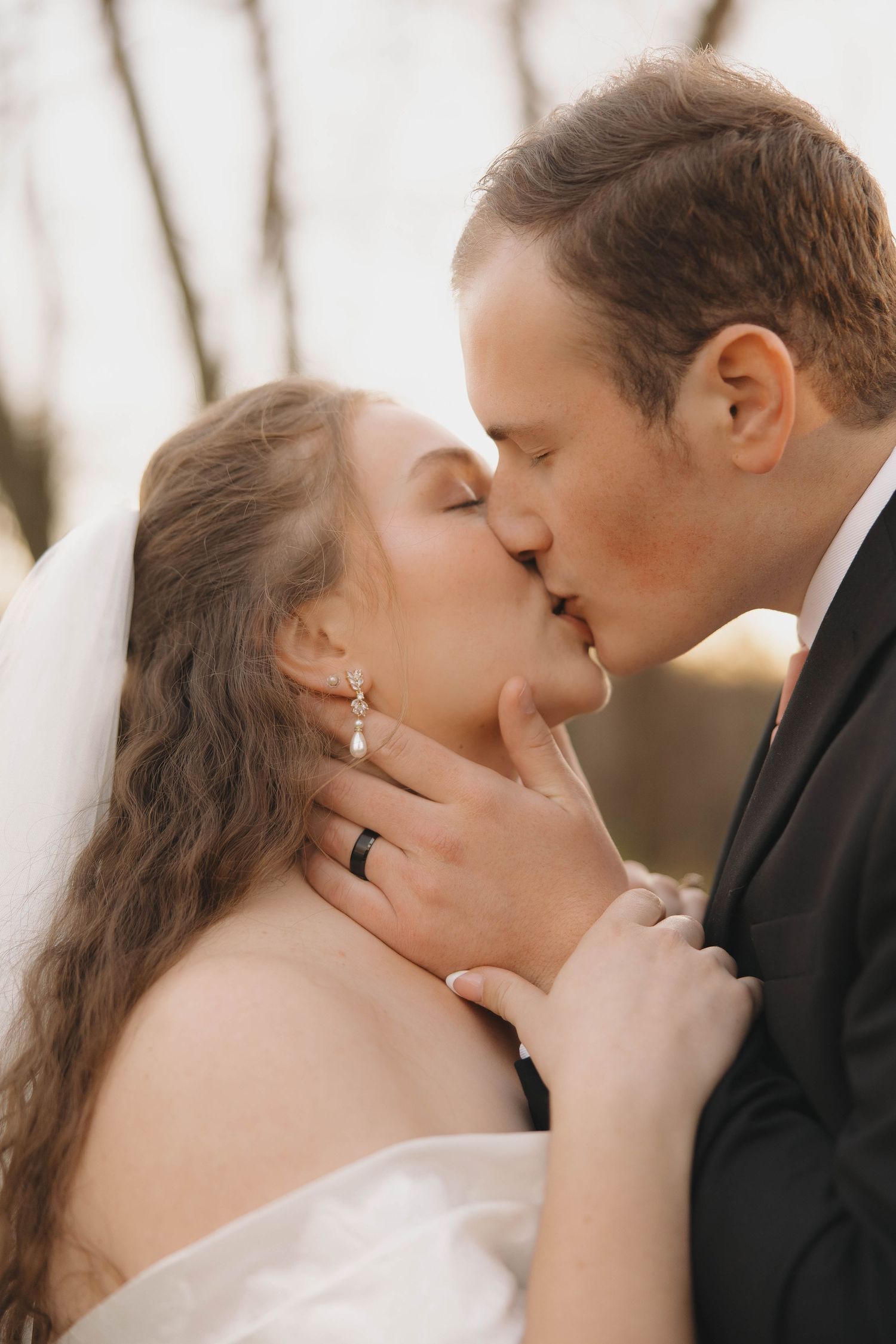 Intimate wedding kiss captured in romantic close-up during autumn ceremony.