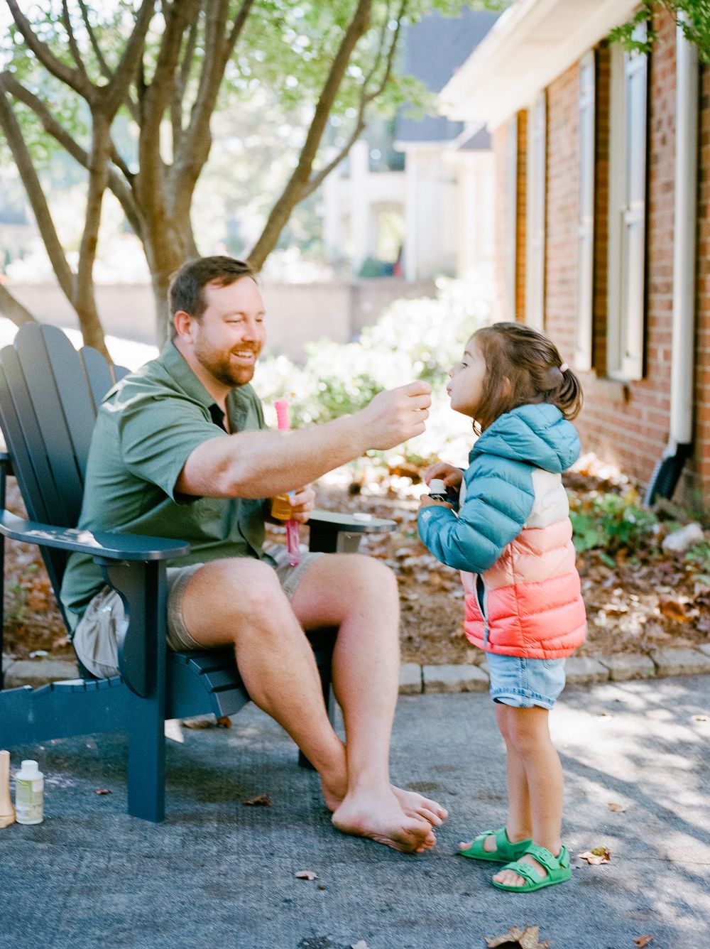 A sequence of playful outdoor moments captured on a porch with a parent and small child in casual attire.