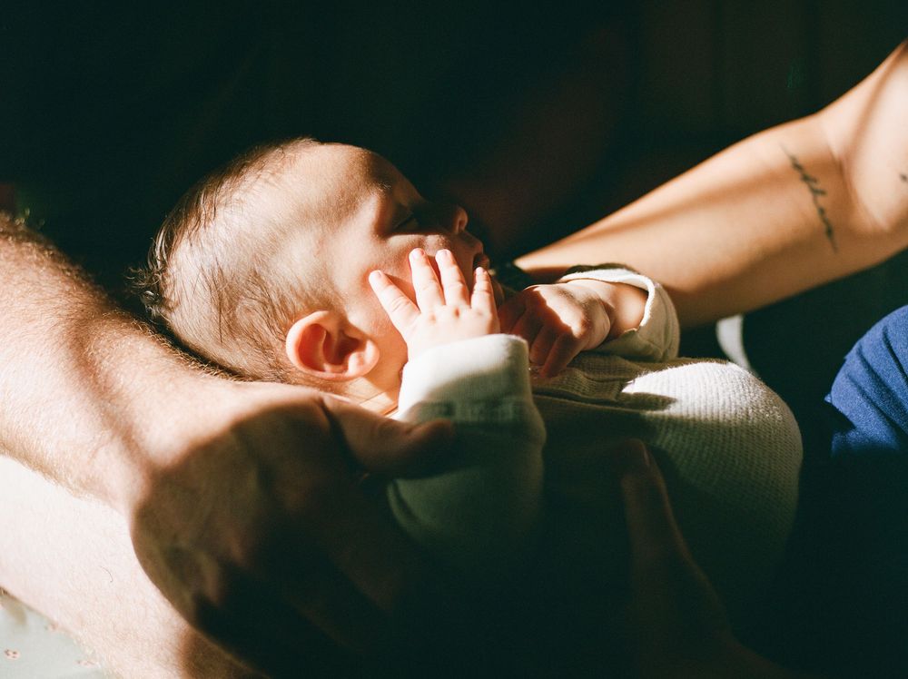 A series of connected intimate black and white photographs showing hands and shadows in dramatic lighting.