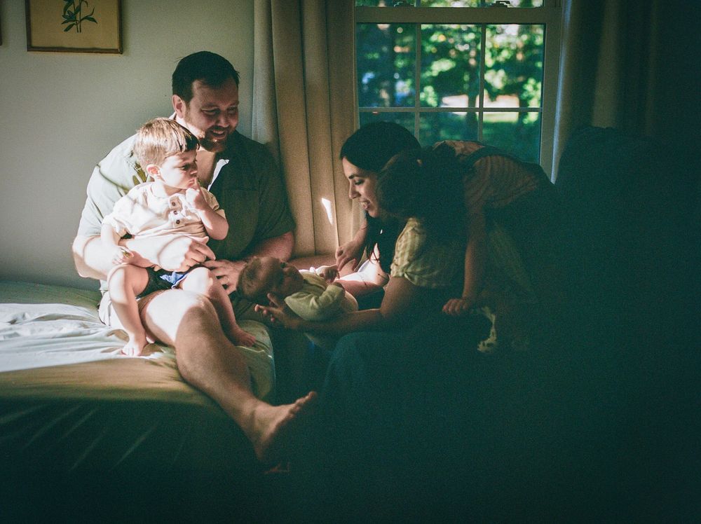 People gathered on a couch in a dimly lit living room setting, creating an intimate atmosphere.