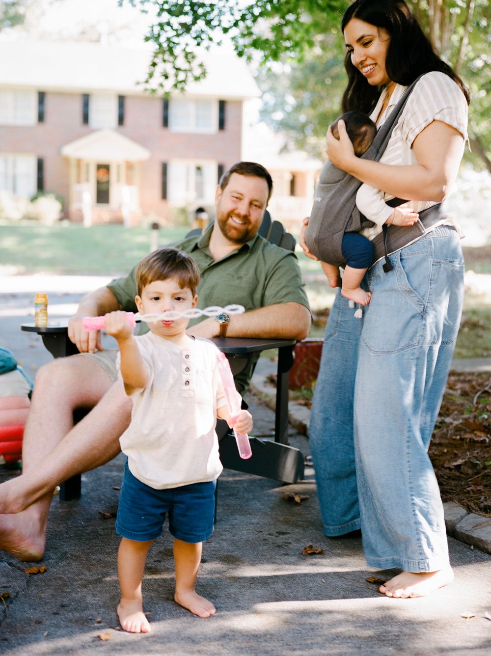 Family spending time together outdoors on a sunny day with casual interactions and playful moments.