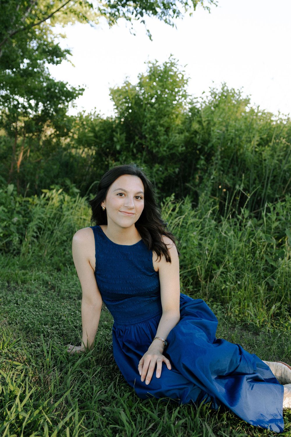 A casual outdoor pose on grass showcases a flowing navy maxi dress.