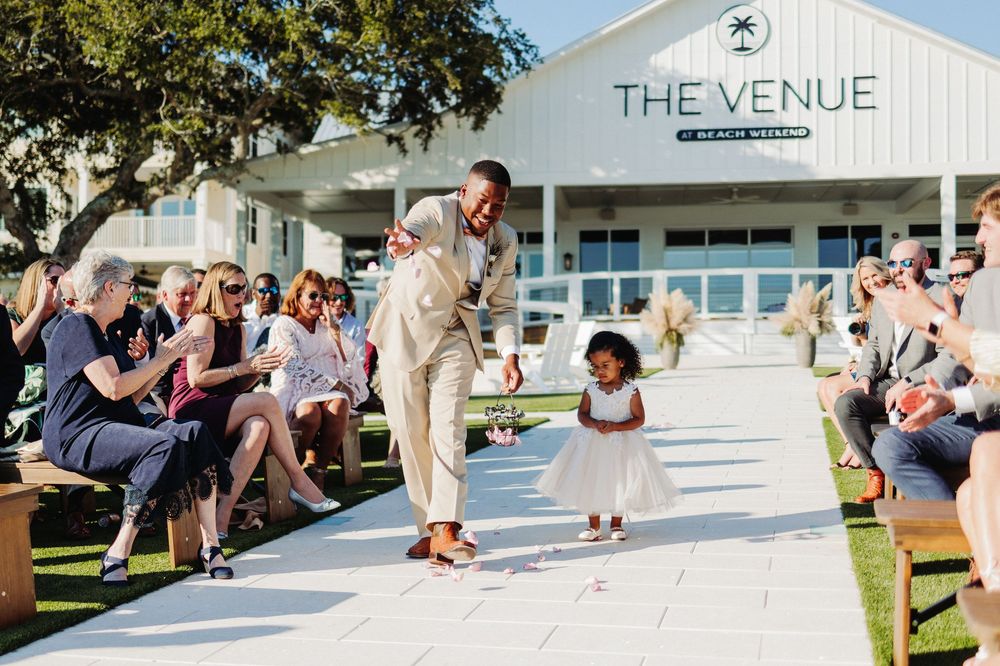 Wedding guests dance together during a joyful celebration at an outdoor venue.