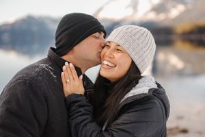Couple wearing winter hats share intimate moments in black and white while bundled up in warm clothing.