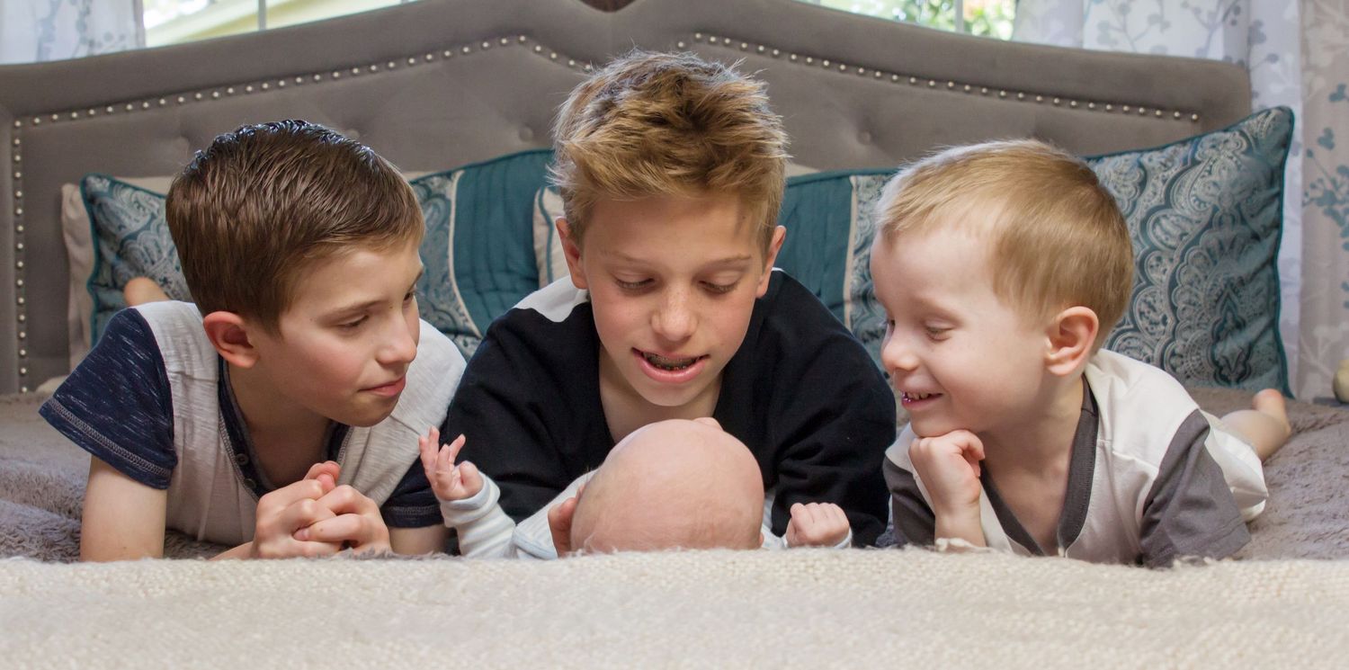 Children lying on the floor looking at something together.