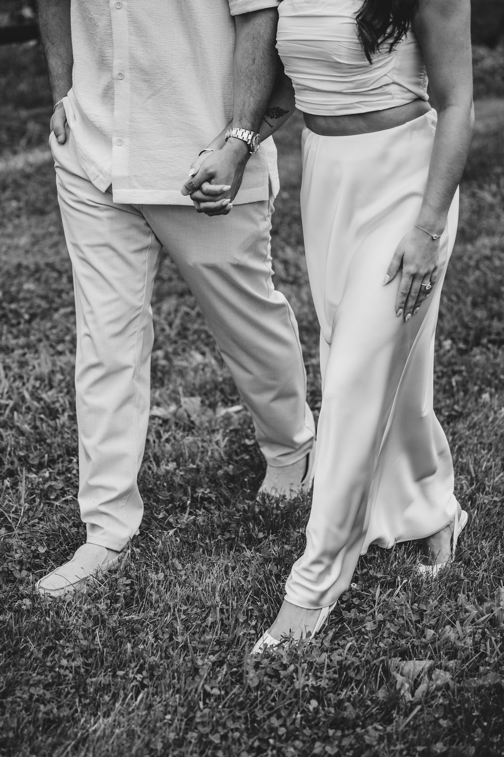 Black and white detail shots of feet and legs during a vineyard proposal moment.